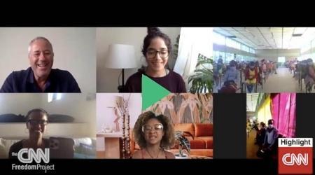 A group of people are sitting in front of a computer screen.