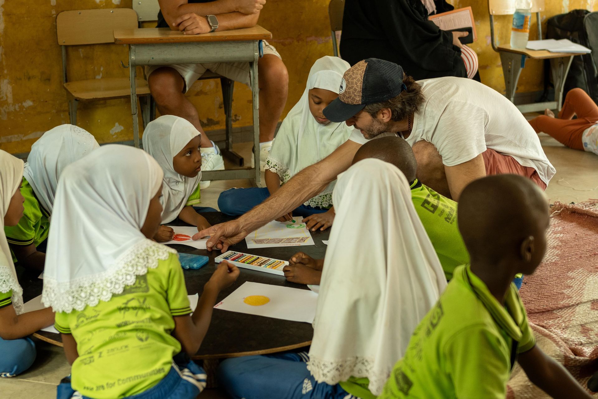 A group of children are sitting on the floor in a classroom