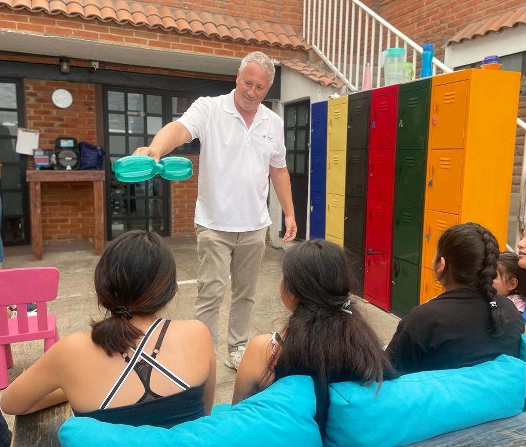 A man is giving a presentation to a group of people sitting on a couch.
