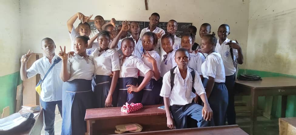 A group of children are posing for a picture in a classroom.