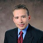 A man in a suit and tie is smiling for the camera. RUBEN TABORDA