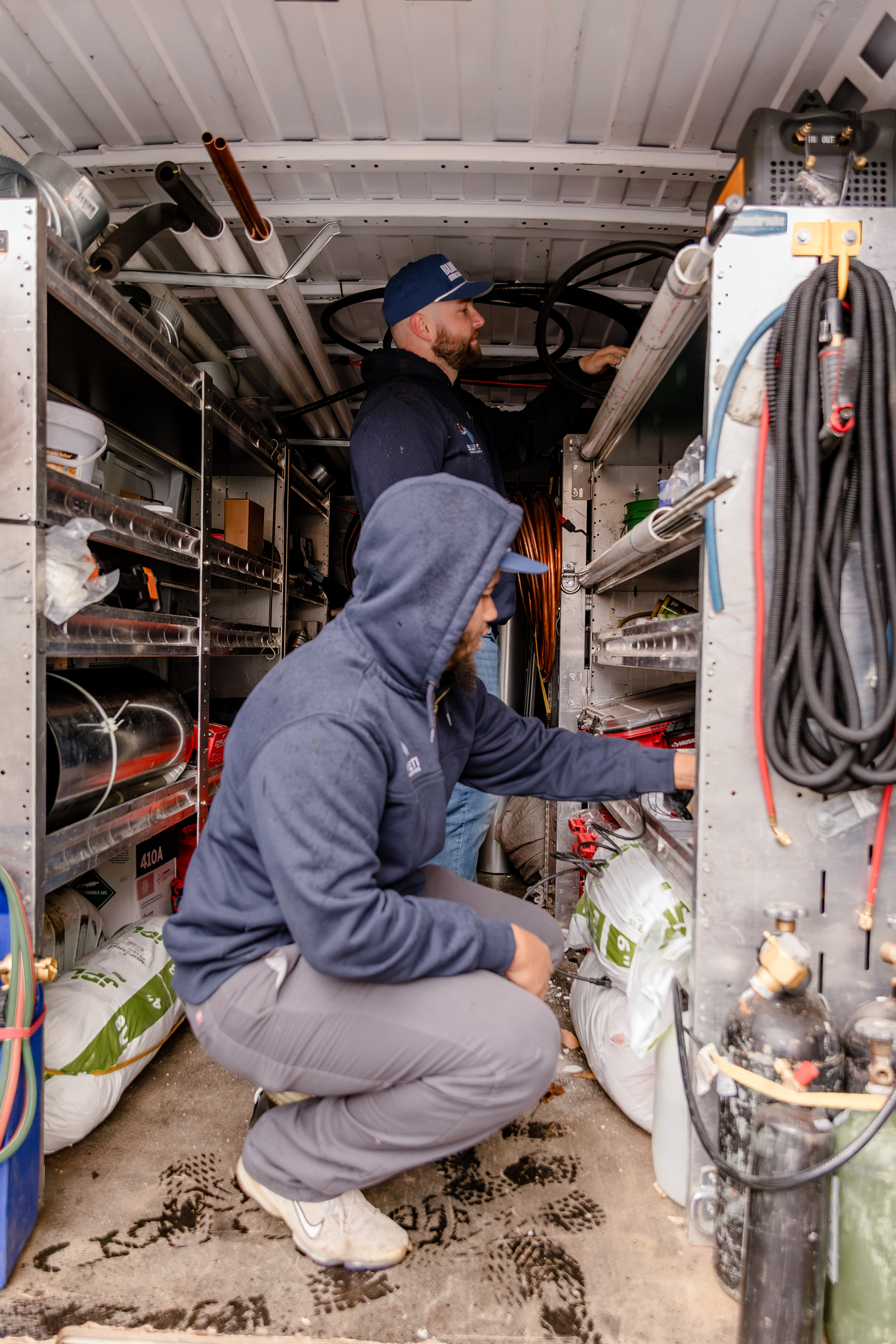 Two Blue Yeti HVAC Plumbing HVAC technicians inside a service truck