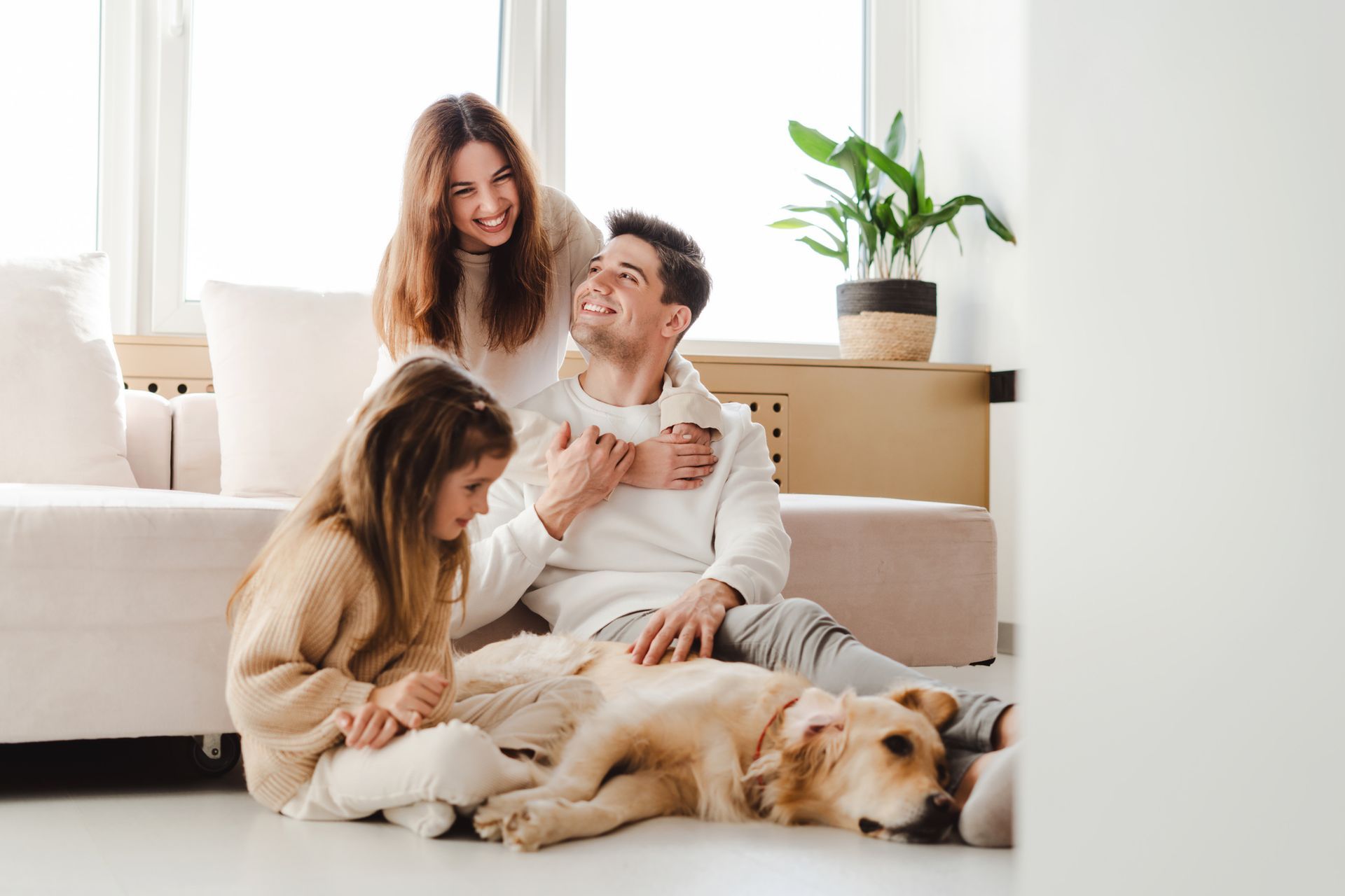 Family and dog relaxing at home with clean air from HVAC purification system.