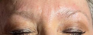 A close up of a woman 's forehead with her eyes closed.