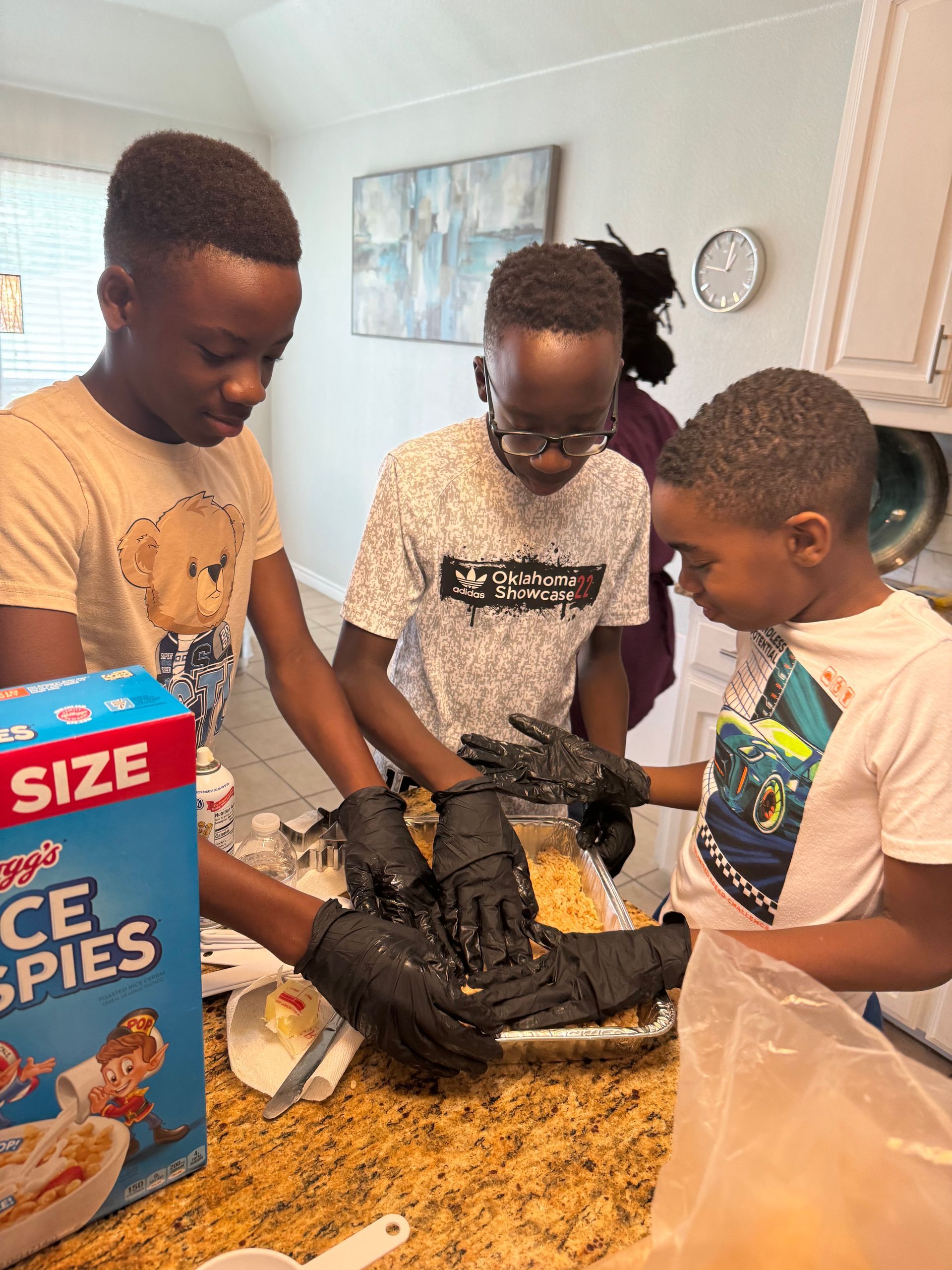 A group of young boys are preparing food in a kitchen.