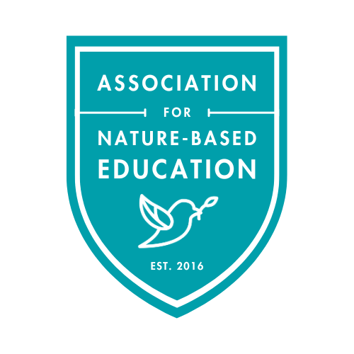 Association for Nature-Based Education teal blue logo in the shape of a badge or shield with bird graphic and established date 2016.