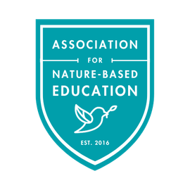 Association for Nature-Based Education teal blue logo in the shape of a badge or shield with bird graphic and established date 2016.