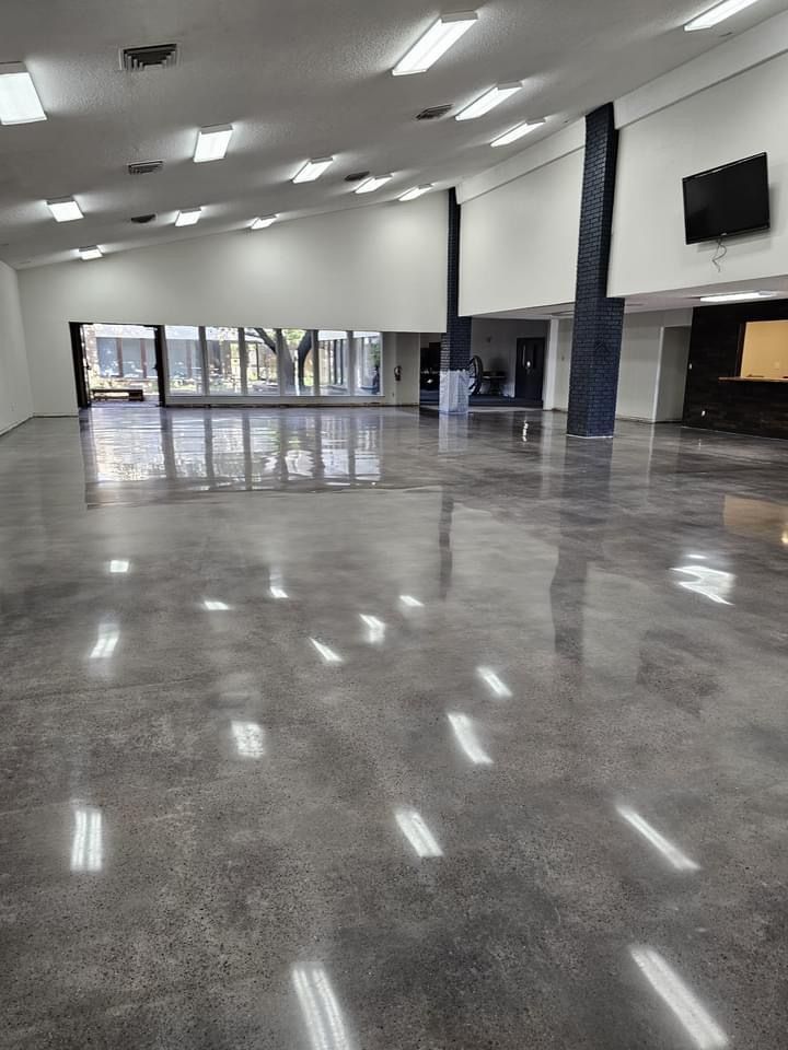 A large room with a shiny concrete floor and white walls.