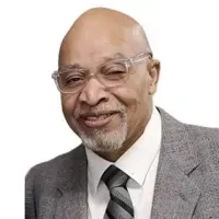 Smiling bald man in glasses and suit against a white background