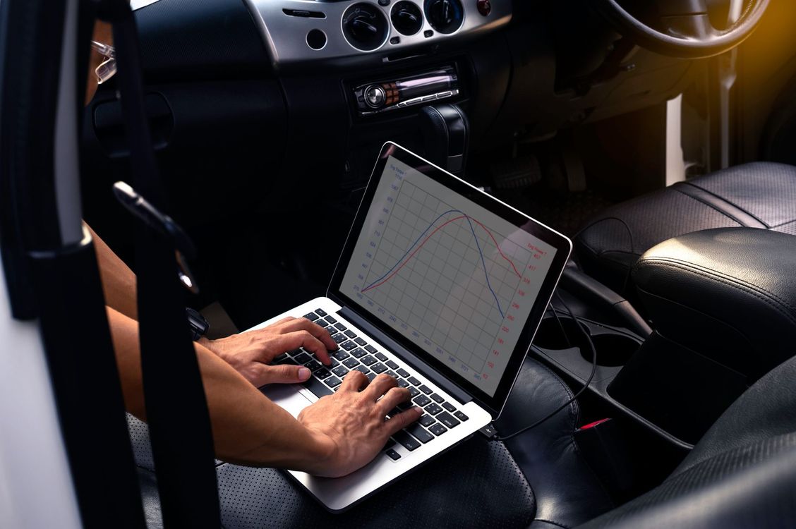 Hands typing on a laptop in a car interior at night
