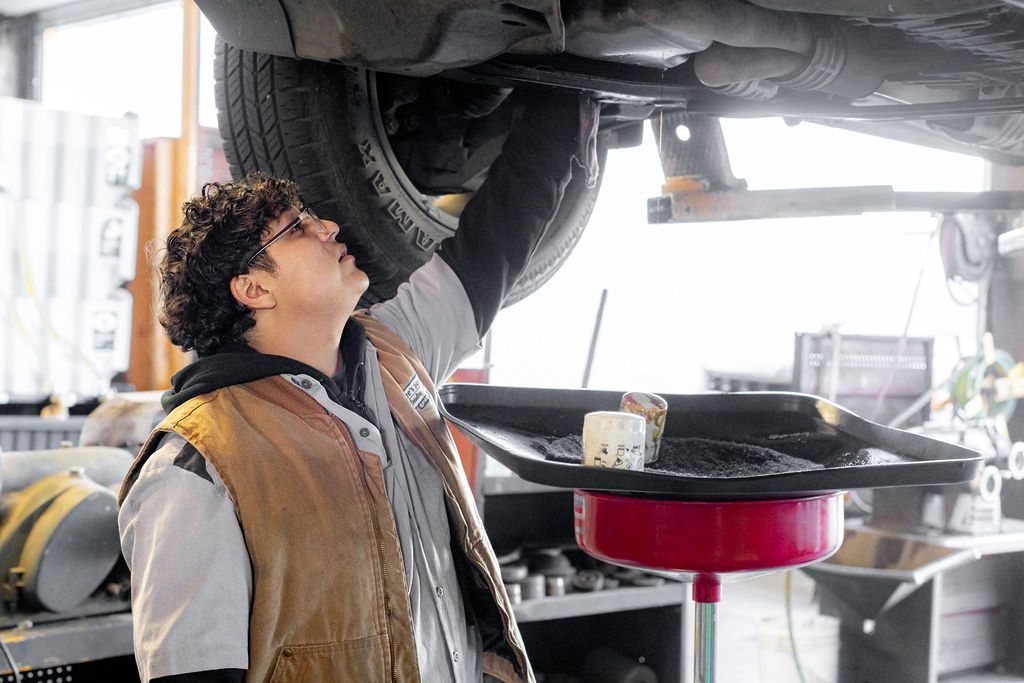 a man is working under a car in a garage