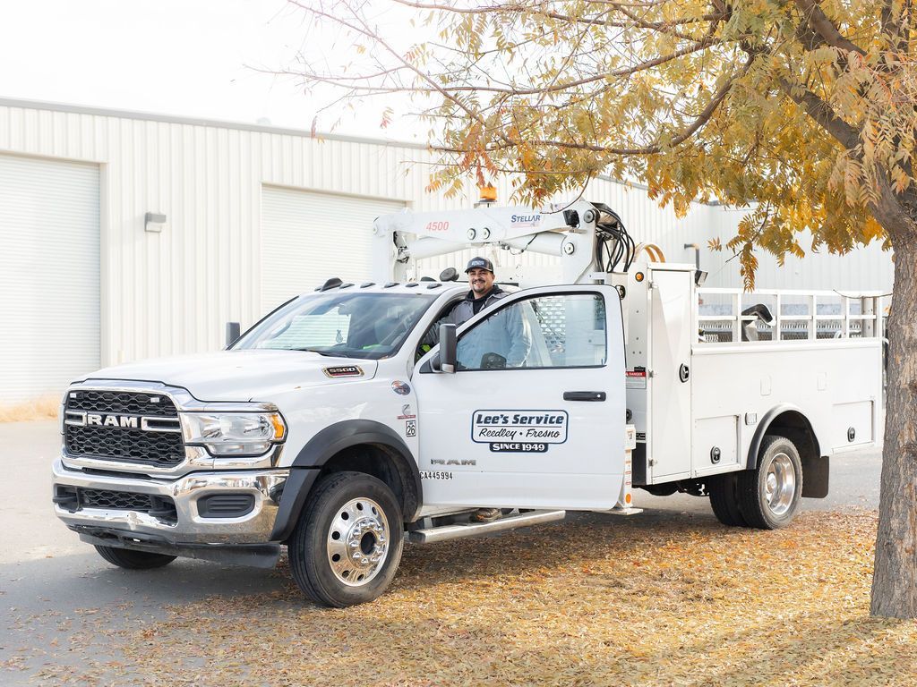 a man is standing in the doorway of a white utility truck .