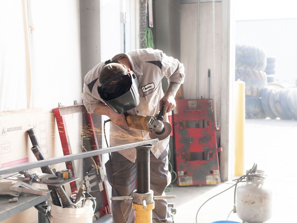 a man wearing a welding helmet is working on a piece of metal