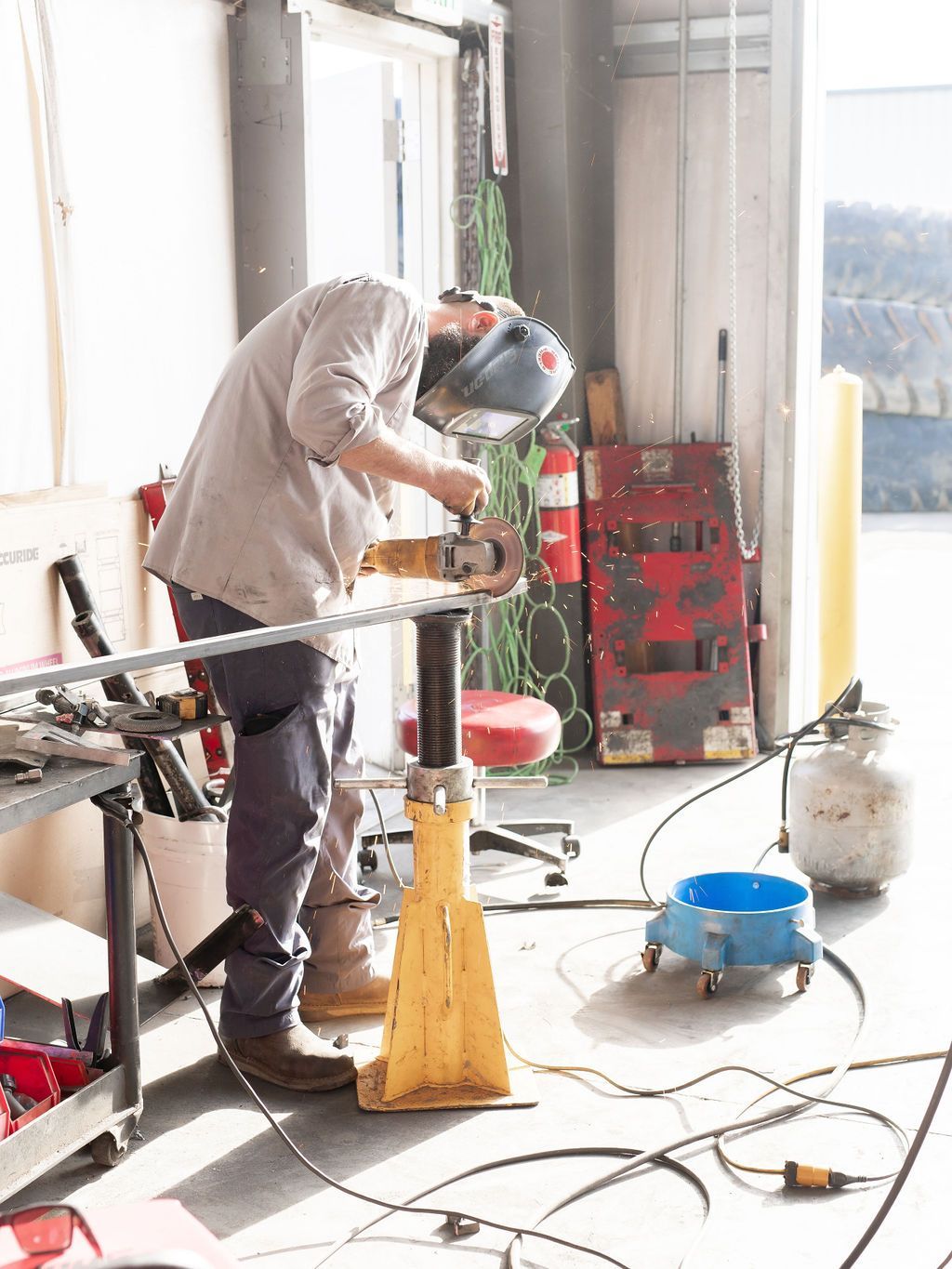 a man wearing a welding helmet is working on a piece of metal
