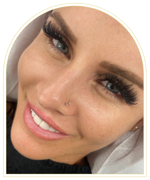 A close up of a woman 's face with long eyelashes and a nose ring.