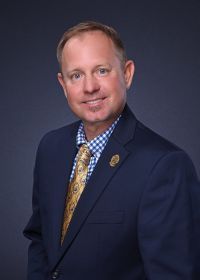 A man in a suit and tie is smiling for the camera.