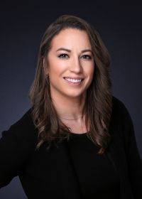 A woman in a black shirt is smiling for the camera.