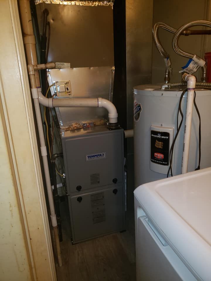 A laundry room with a water heater and a furnace.