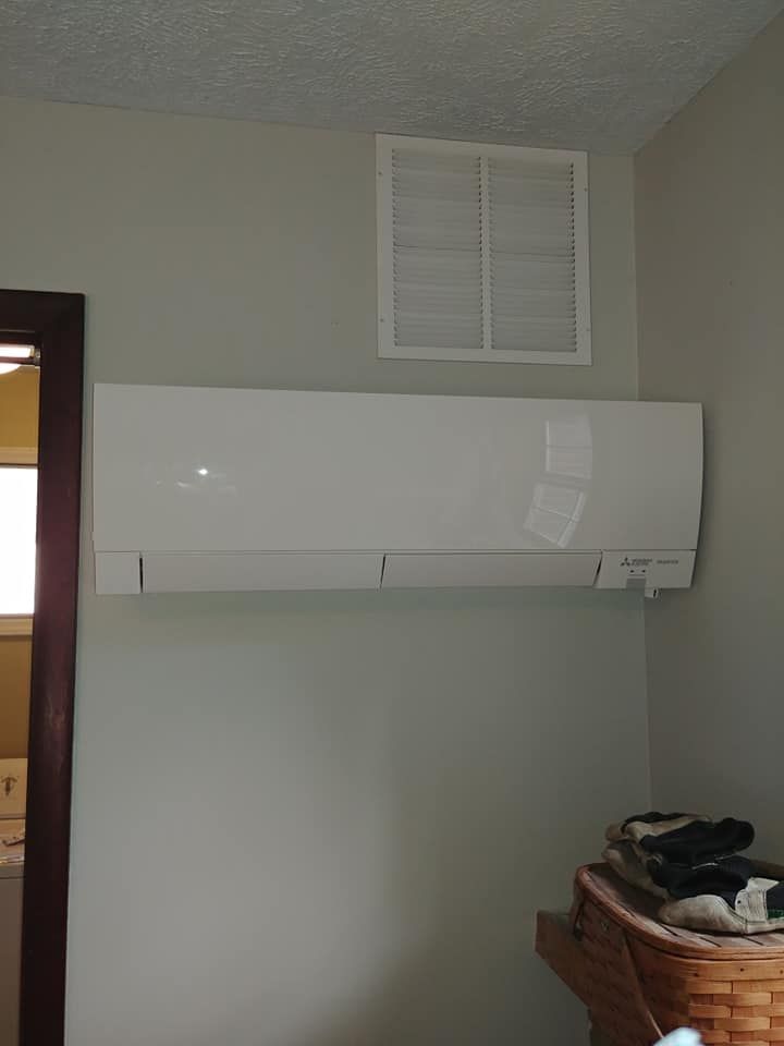 A white air conditioner is hanging on a wall in a room.