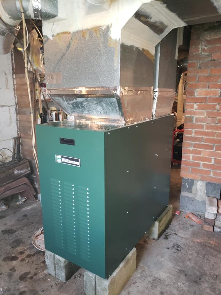 A green box is sitting on top of a brick wall in a room.