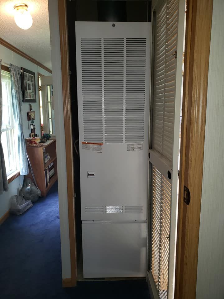 A white heater is sitting in a hallway next to a door
