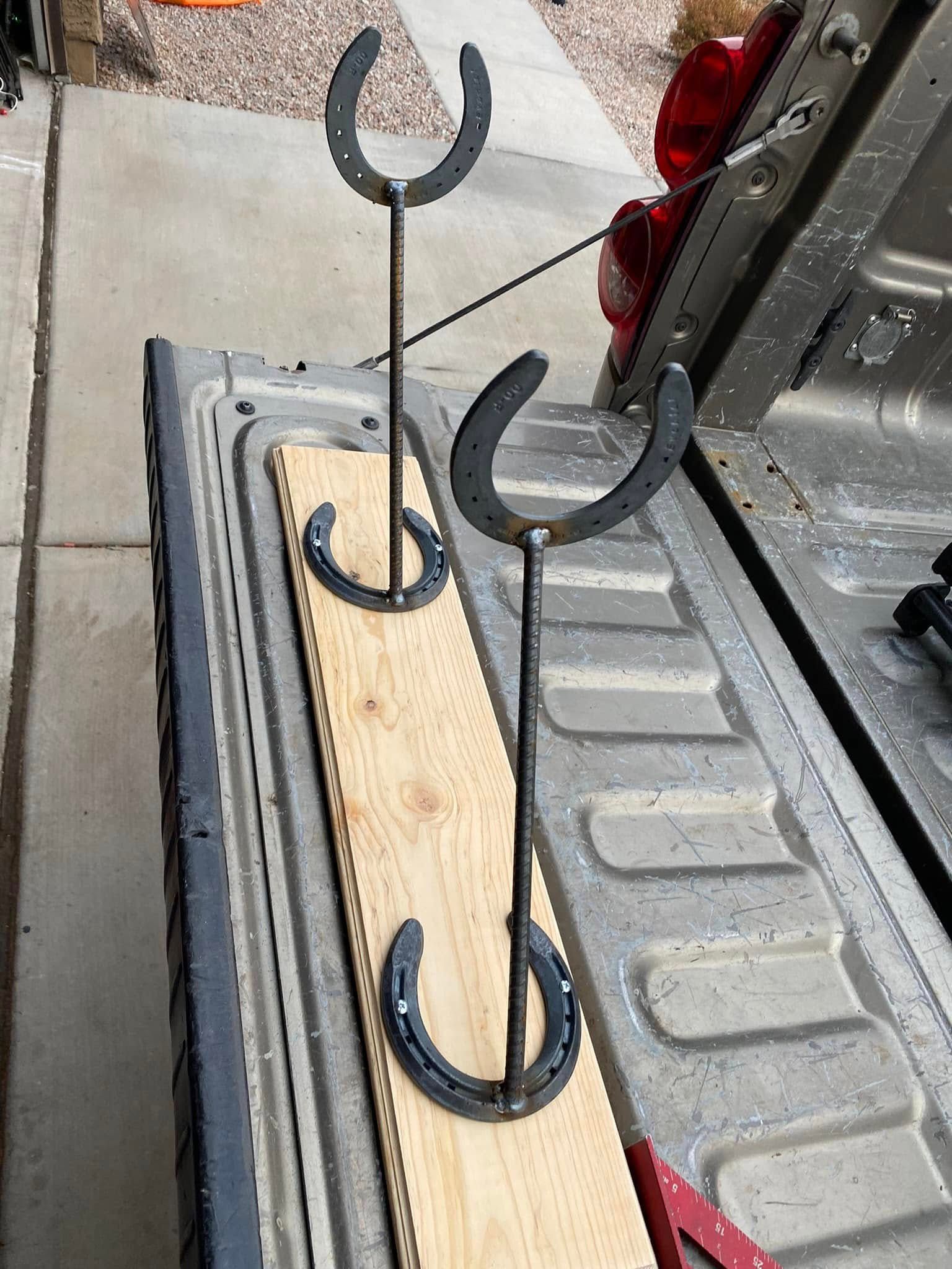 Three metal hooks attached to a wooden board in a truck bed