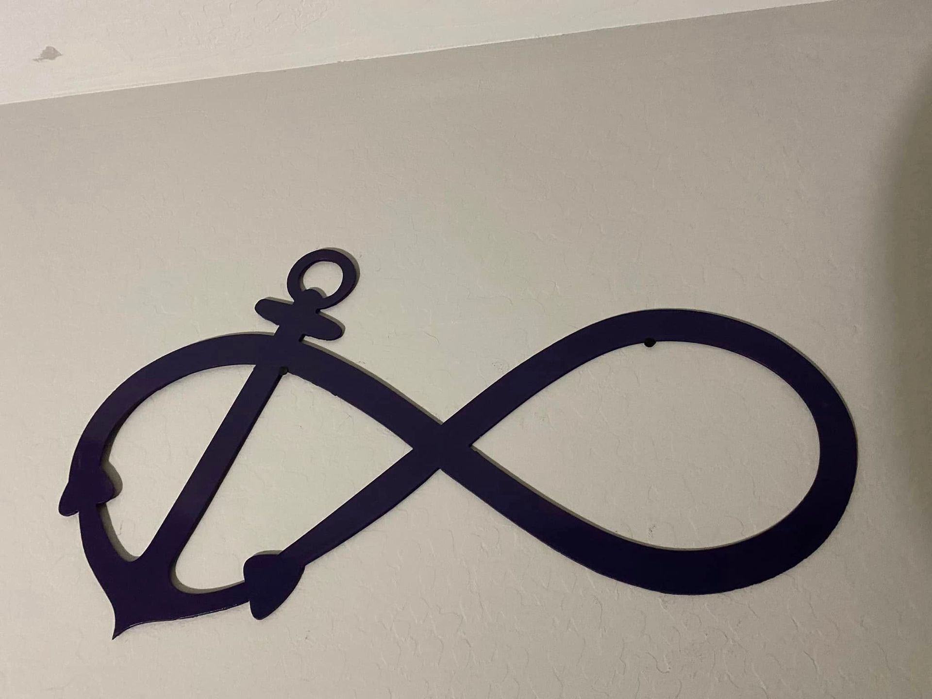 Black infinity symbol with a small looped tail on a light background