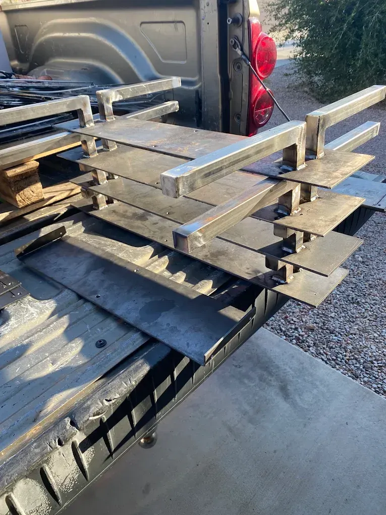 Stacks of wooden pallets loaded in the bed of a pickup truck outdoors
