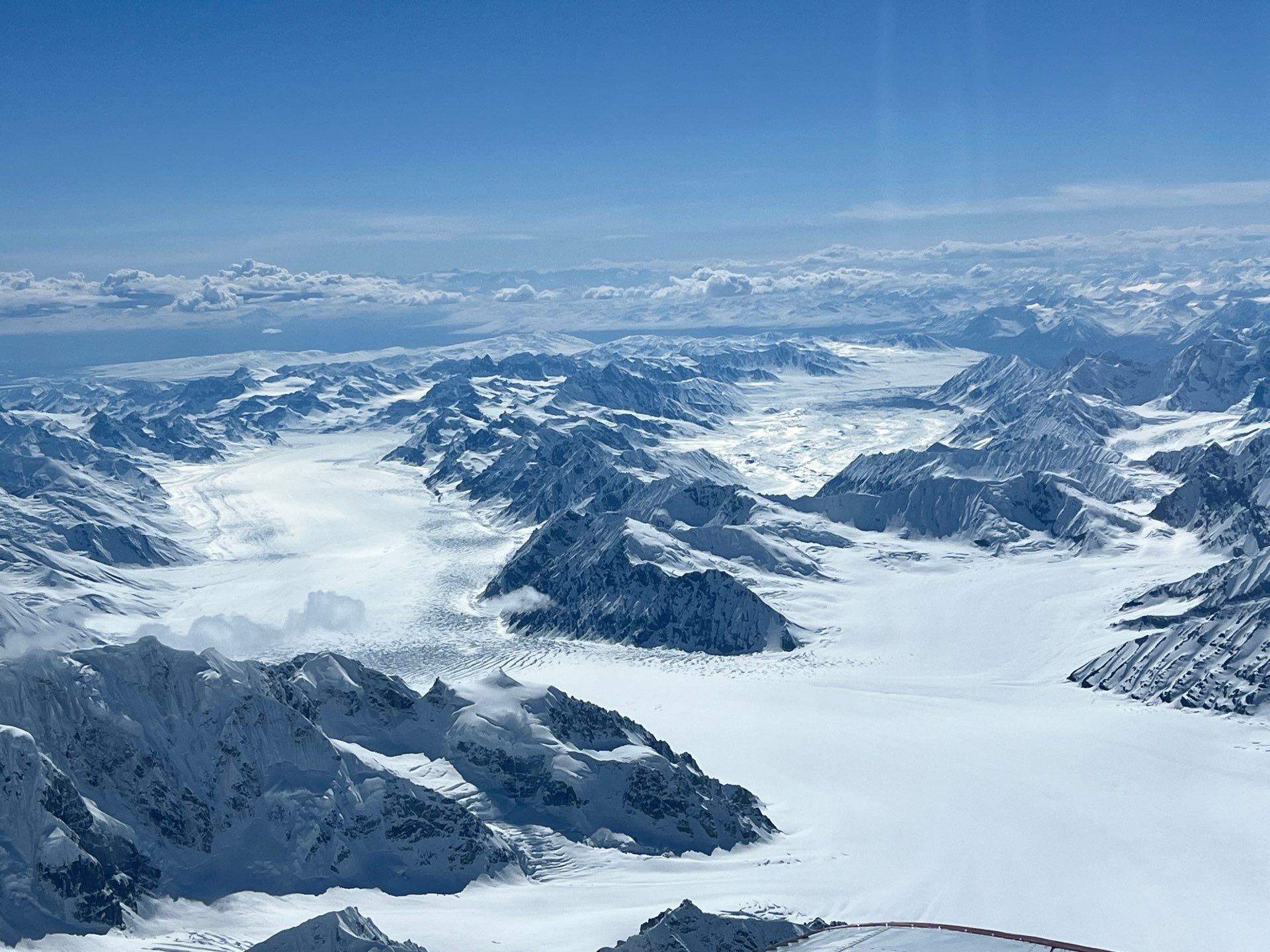 Snow-covered mountain range and glacier under a clear blue sky
