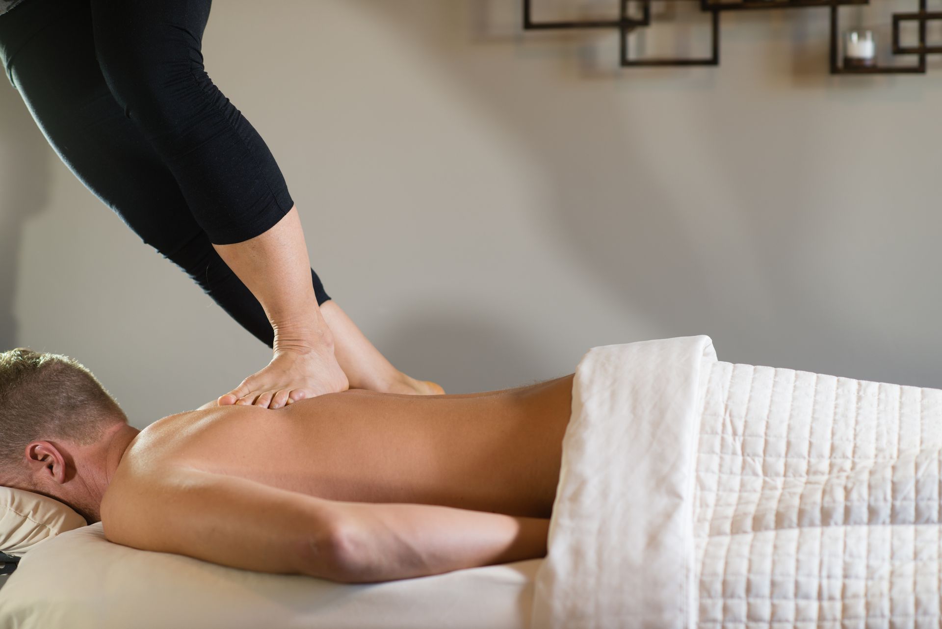 A Man Is Laying on a Table Getting a Massage From a Woman — Ocean Isle Beach, NC — OIB Massage