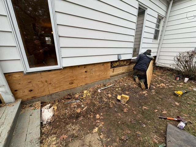 A man is working on the side of a house.