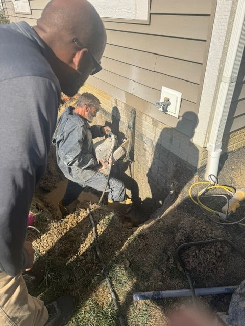 Two men are working on the side of a house.