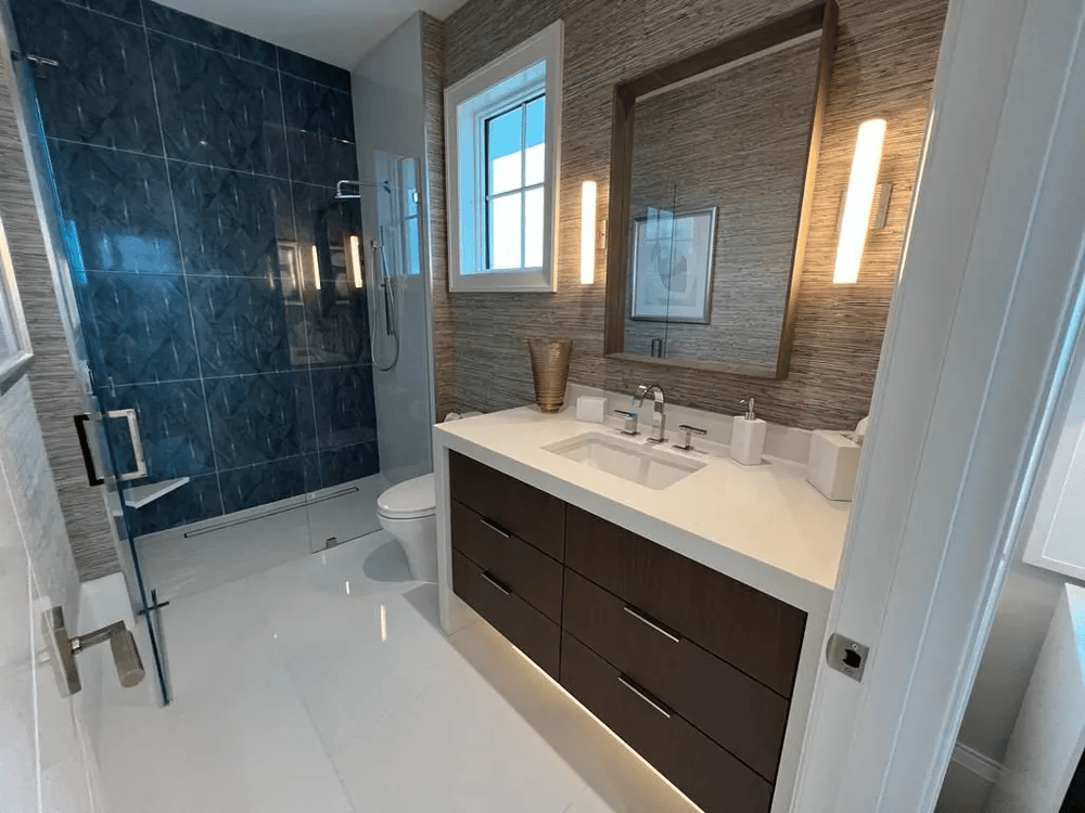 Modern bathroom with dark wood vanity, white countertop, glass shower, and blue tile accent wall