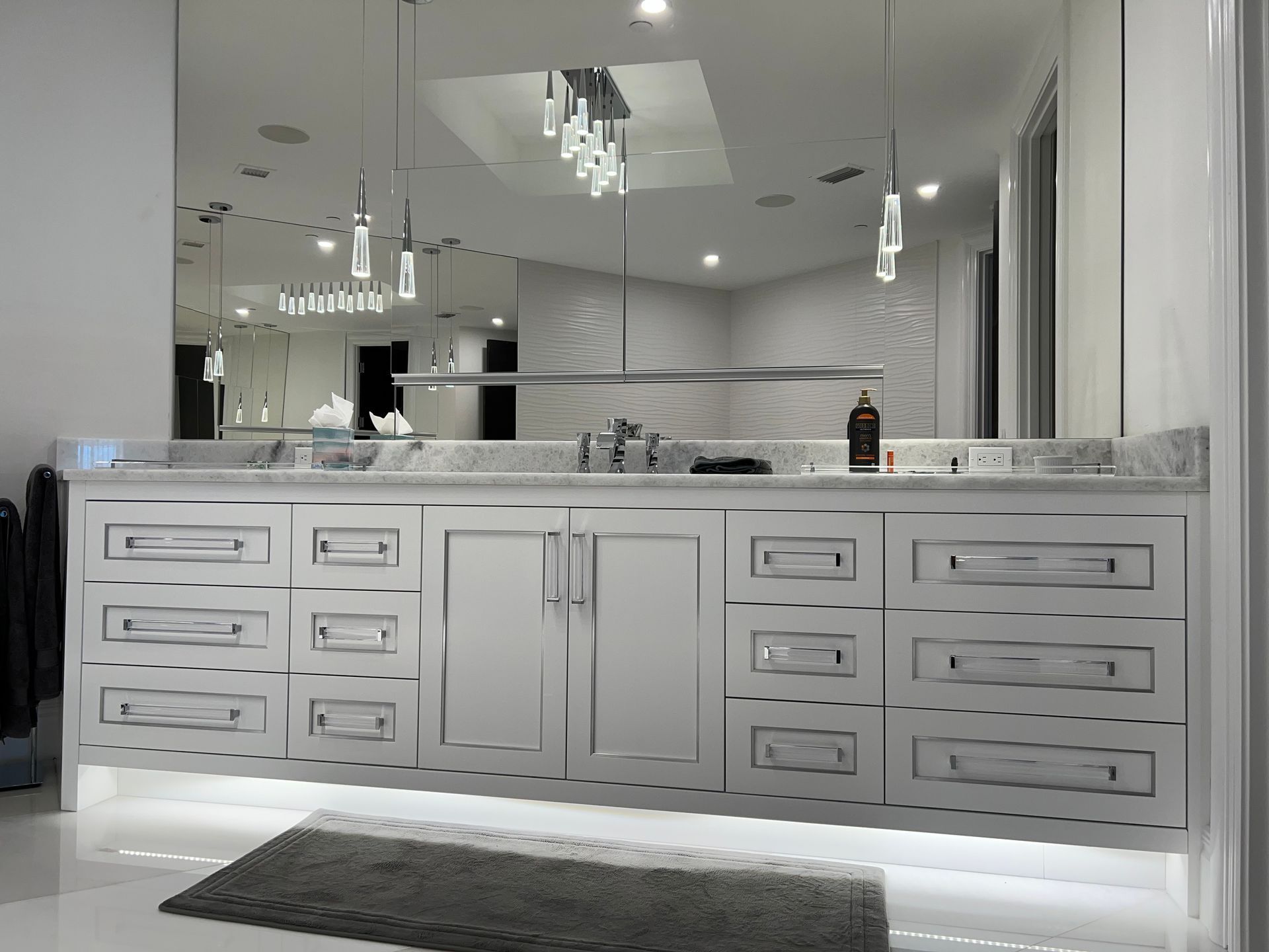 Modern bathroom vanity with double sinks, mirrors, and white cabinetry in a bright, elegant interior