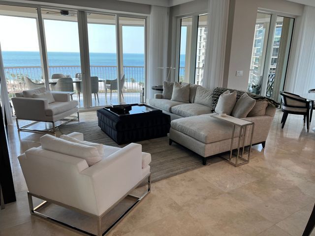 Modern living room with beige seating and ocean view through large windows