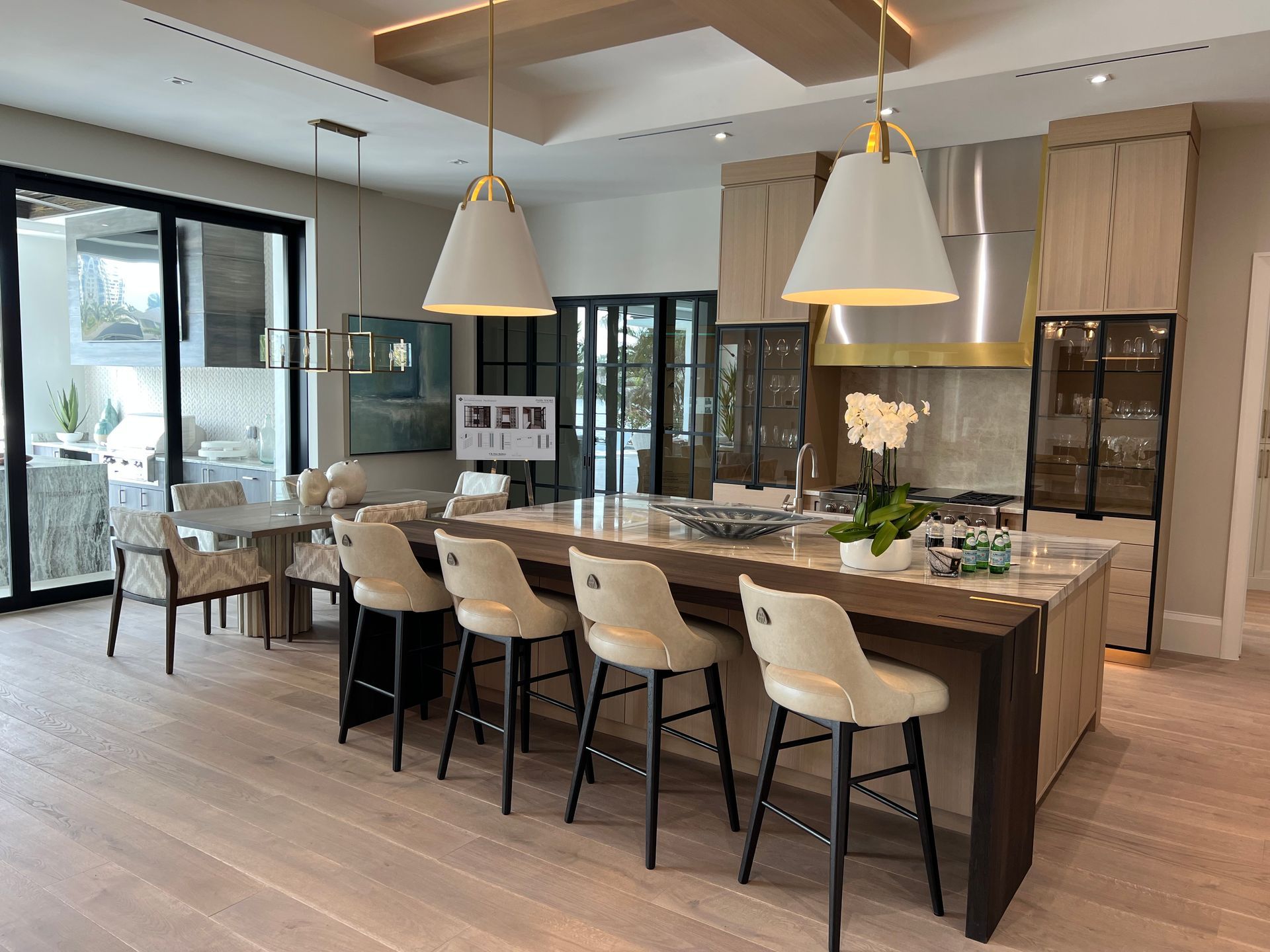 Modern kitchen with large island, pendant lights, bar stools, and open dining area