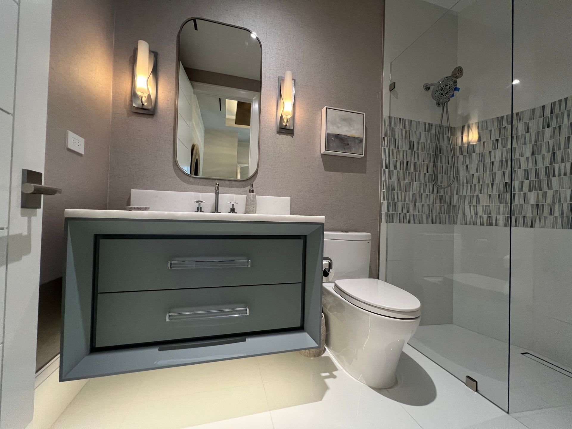 Modern bathroom with gray vanity, mirror, toilet, and glass shower enclosure