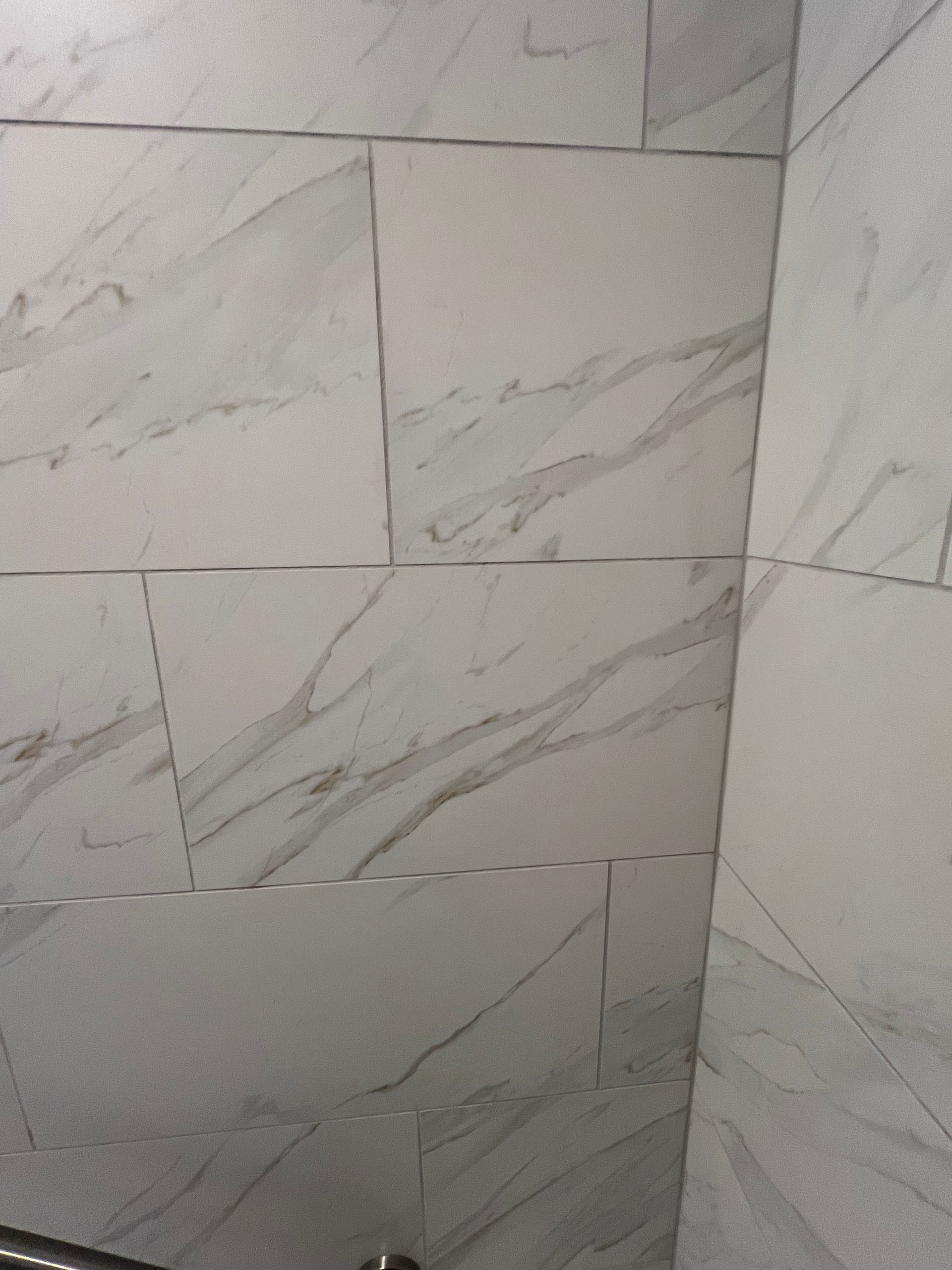 Light gray marble-tile wall with thin dark veining and a few visible grout lines