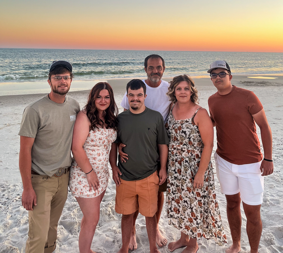 A group of people posing for a picture on the beach