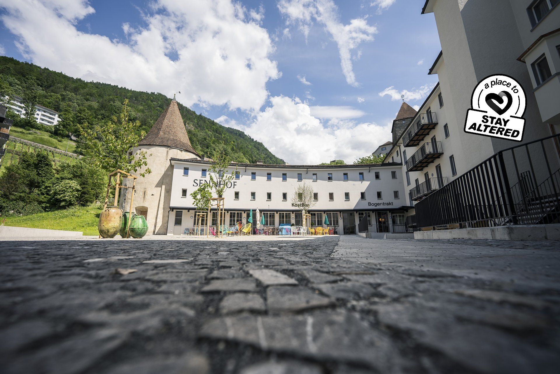 Ein Gebäude mit einem Turm darauf ist von Bergen umgeben.