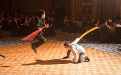 Two young boys are playing with balloons on a dance floor.