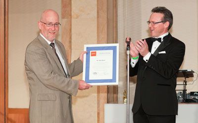 ACCJ Volunteer of the Year, Andy Boone, on stage receiving his award at the 2013 Champagne Ball