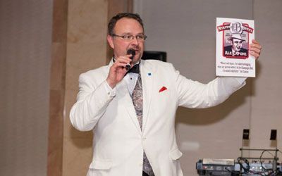 Deryk Langlais emceeing a gala event.