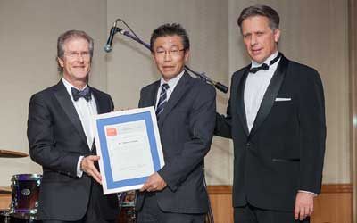 ACCJ Volunteer of the Year, Takashi Omitsu on stage receiving his award at the 2015 Champagne Ball.