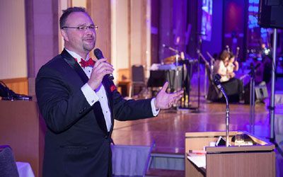 Deryk Langlais emceeing a gala event.