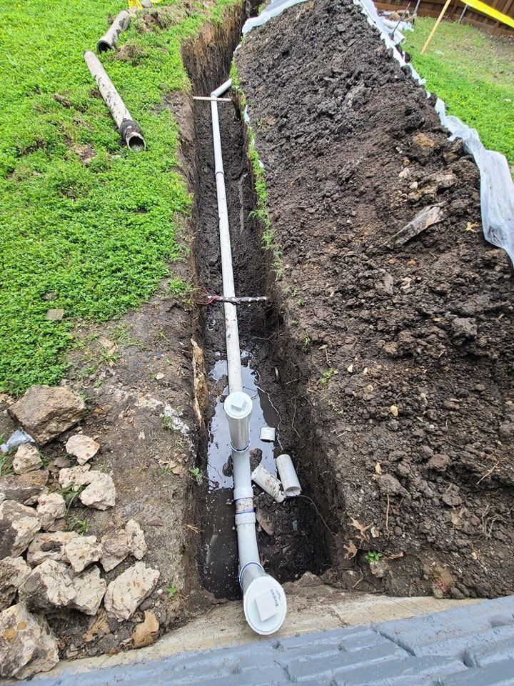 A drain pipe is being installed in a trench.