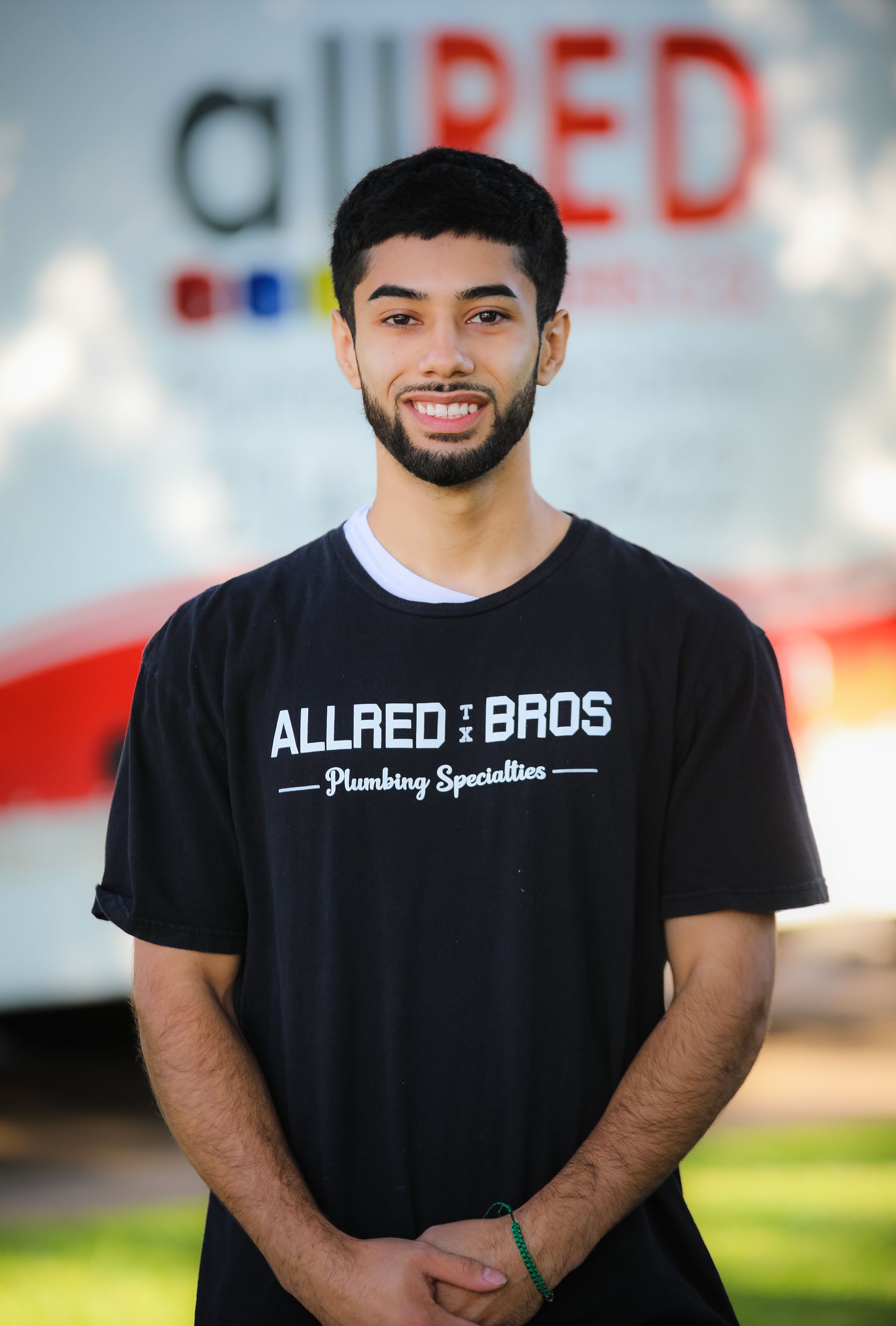 A man wearing a black shirt that says allred bros