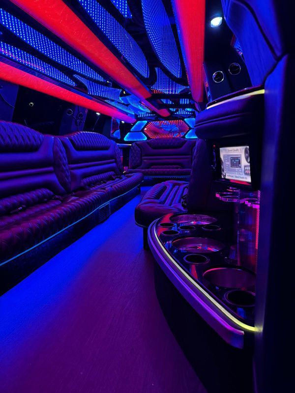 The inside of a limousine with purple and red lights.