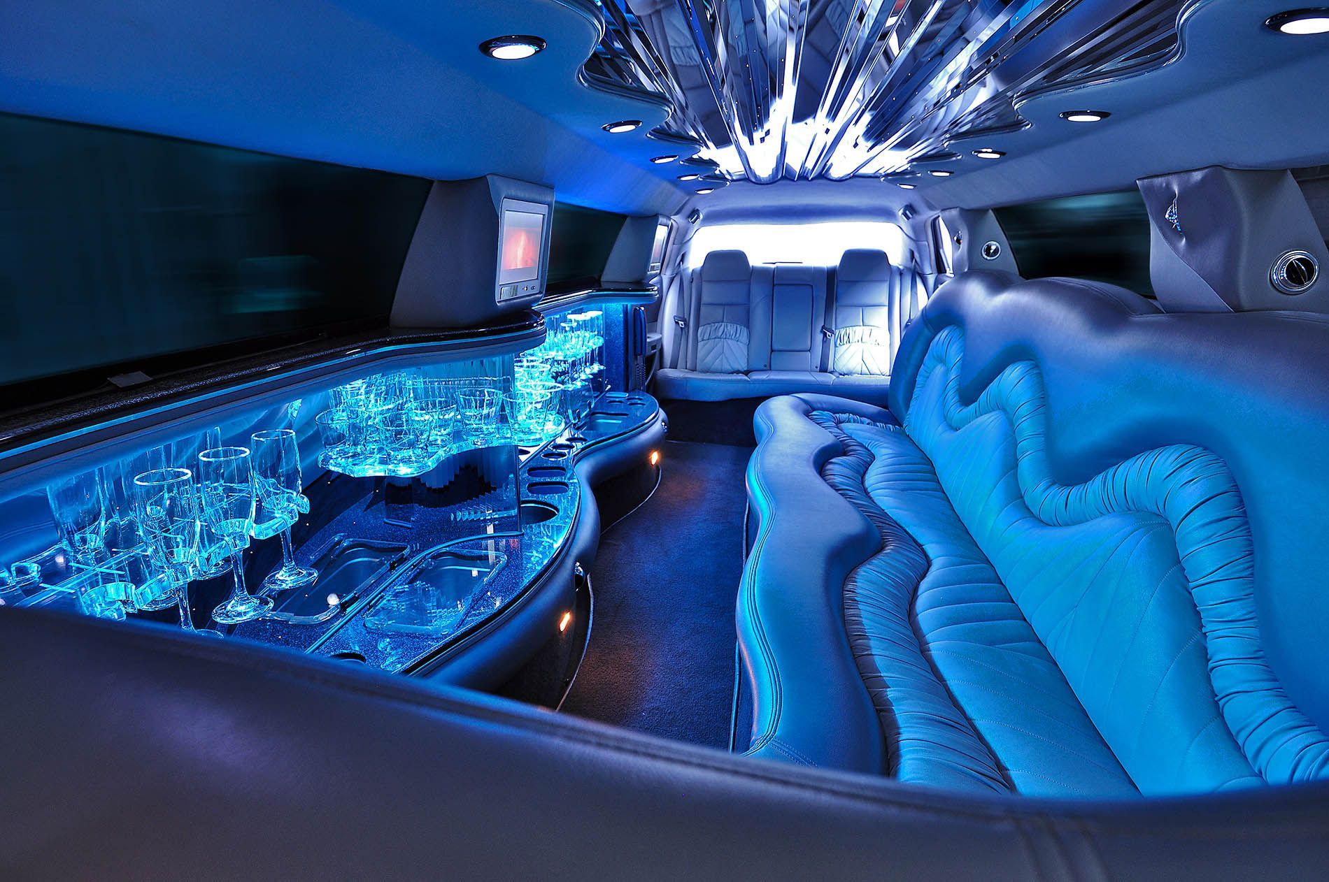 The inside of a limousine with blue lights on the ceiling