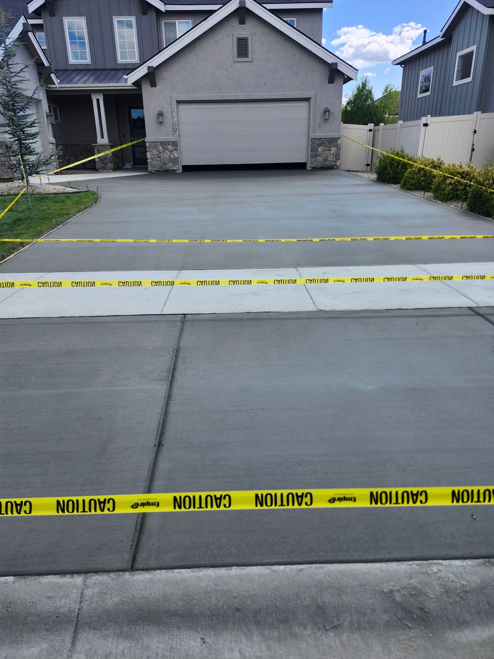 Police tape blocking a residential driveway and street after an incident